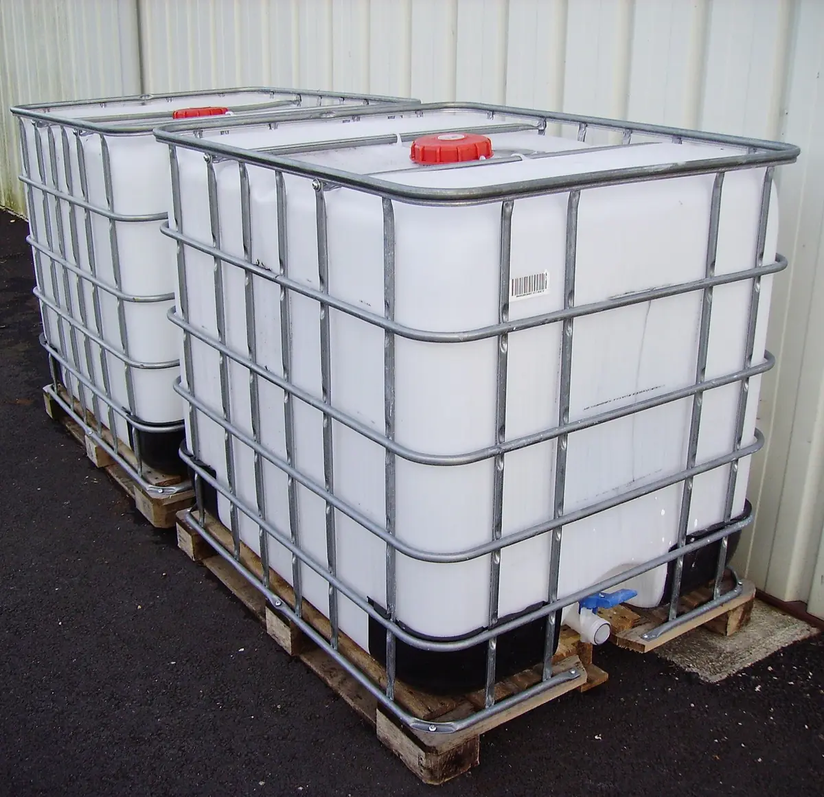 New white IBC totes in galvanized cages on wooden pallets